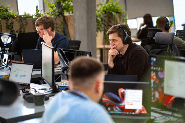 Software developers working at computers in a modern office environment.
